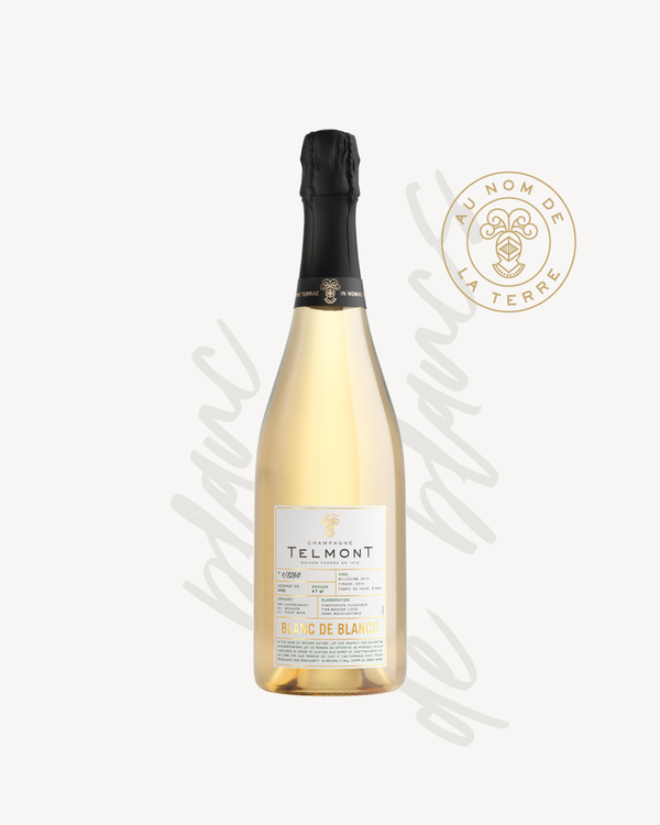 A packshot of a bottle of Champagne Telmont Blanc de Blancs, text in the background, Telmont stamp on the right